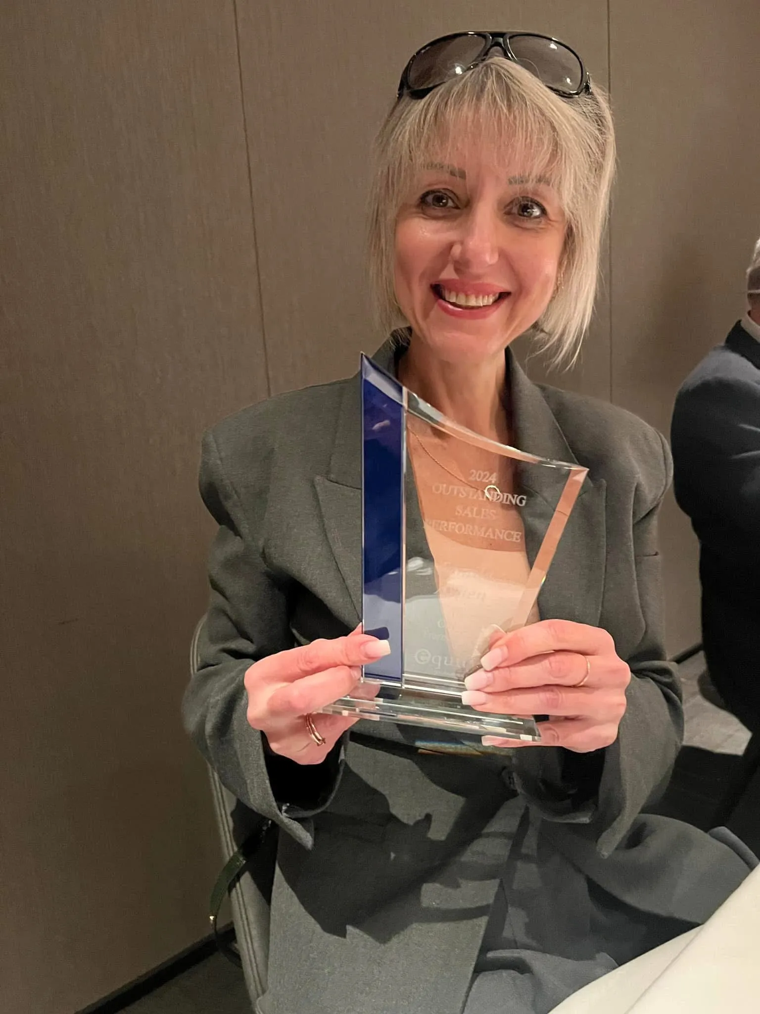 Tamila Aspen holding her 2024 Outstanding Sales Performance award from Equity Colorado Real Estate
